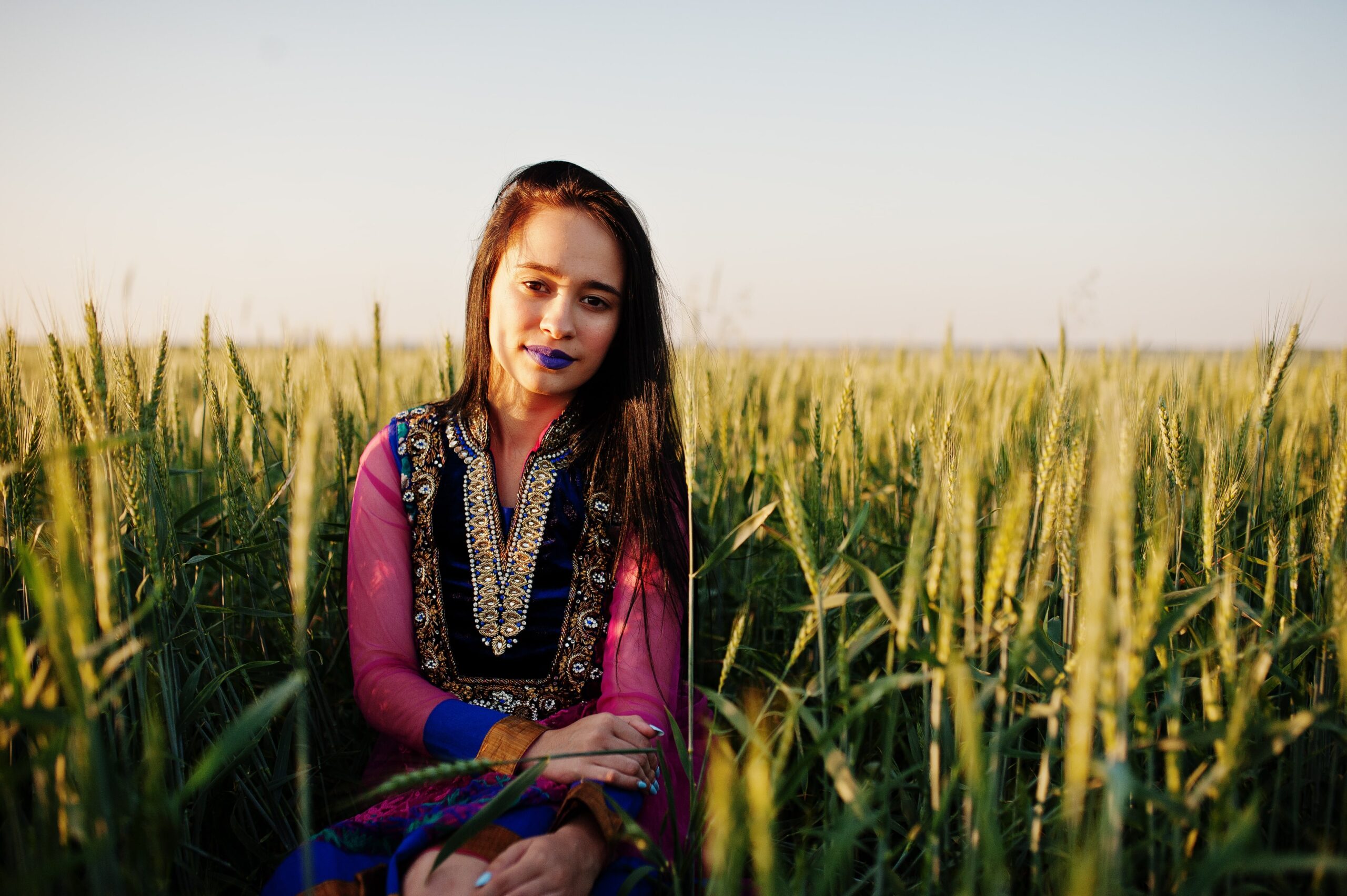 tender-indian-girl-saree-with-violet-lips-make-up-posed-field-sunset-fashionable-india-model-min